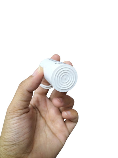 Hand holding white 3.75uF 250V AC capacitor from Syscap electrical circuitry parts