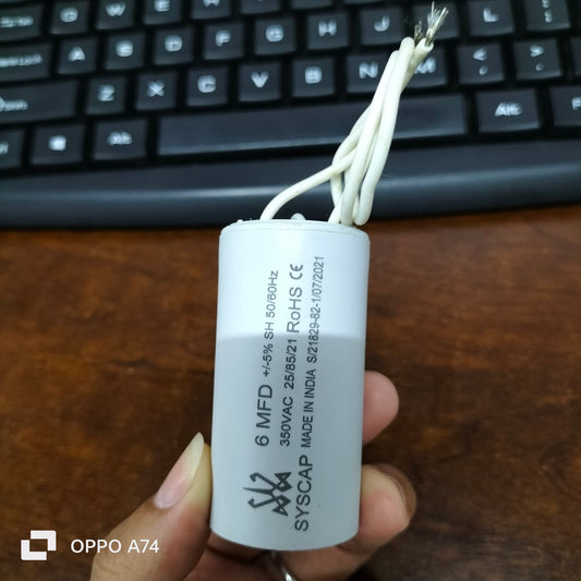 SYSCAP 350VAC Capacitor for Motors white cylindrical capacitor with wires held in hand over keyboard