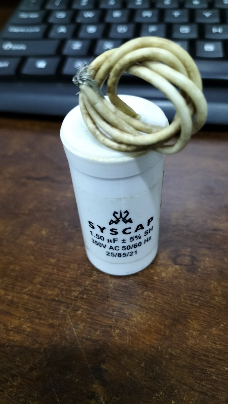 SYSCAP 350VAC running capacitor with white casing and wires, designed for electrical circuit applications