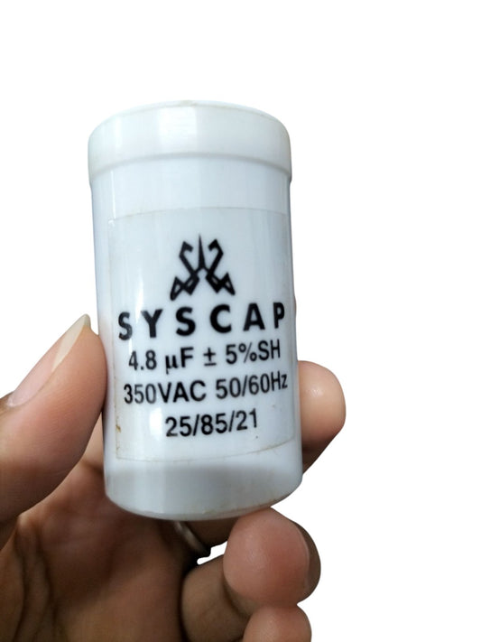 Syscap 4.8 microfarad 350V AC capacitor held in hand for electrical circuitry and parts