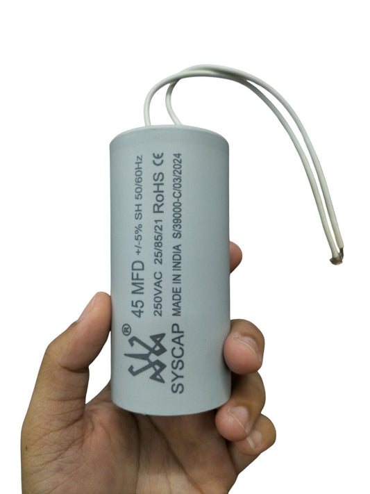 Syscap electrical motor capacitor 45 MFD 250VAC held in hand with white wires for motor applications