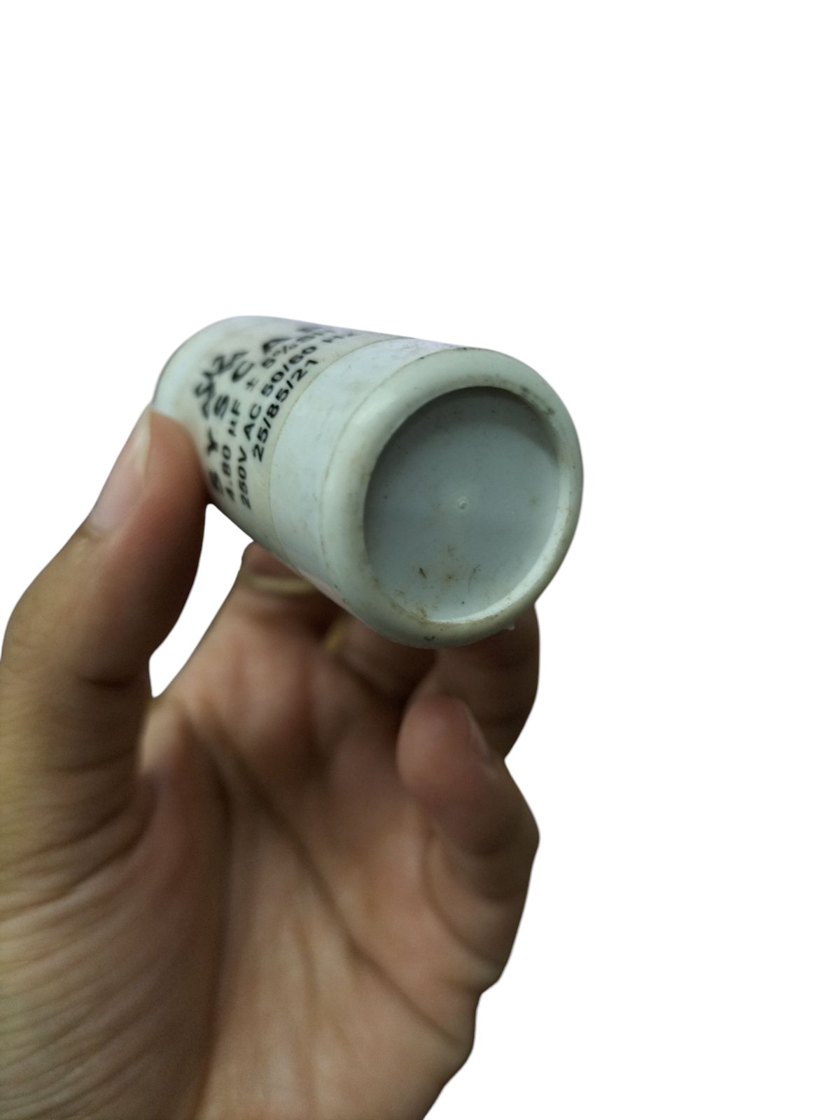 Hand holding a SYSCAP motor capacitor 250V AC showcasing its cylindrical design and printed specifications