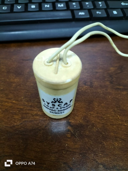 SYSCAP Motor Running Capacitor 1MFD 600V AC cylindrical electrical component with two white wires on wooden surface