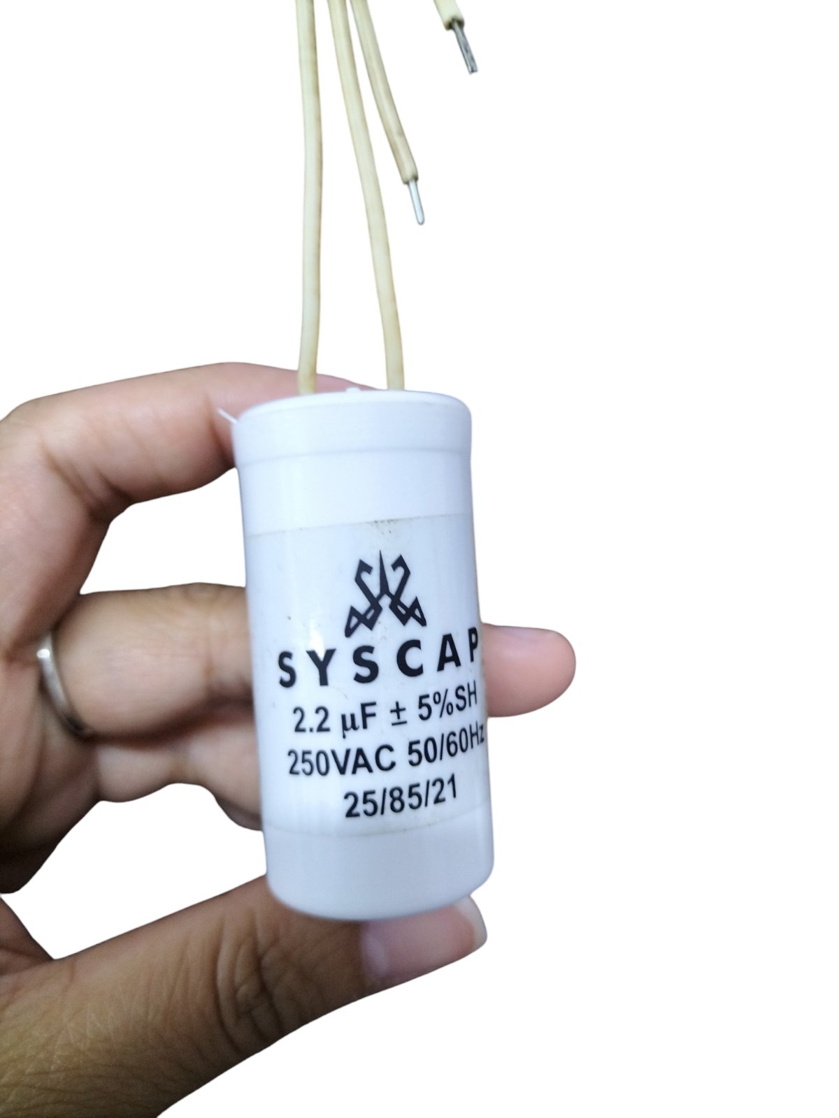Syscap motor running capacitor 2.2mfd 250v held in hand for electrical circuitry use