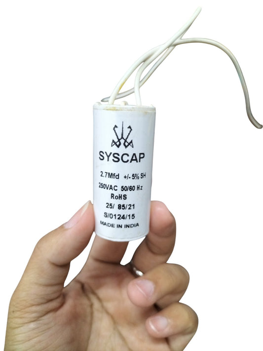 Syscap Motor Running Capacitor 2.7MFD250v held in hand with white wires attached