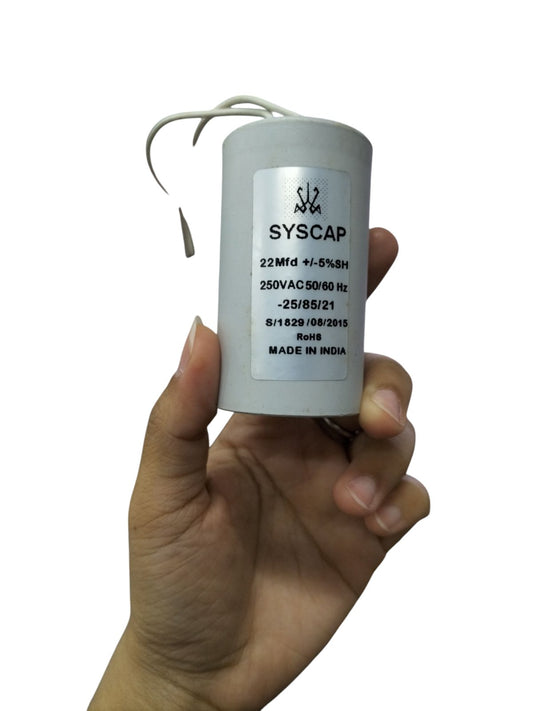 Syscap motor running capacitor 22MFD held in hand for electrical circuitry applications