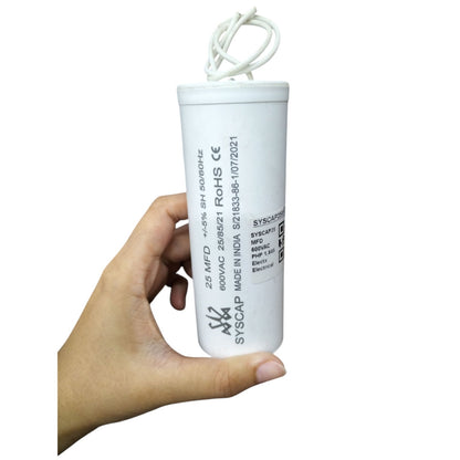 Hand holding Syscap motor running capacitor 25uF 600V with two wires for electrical applications
