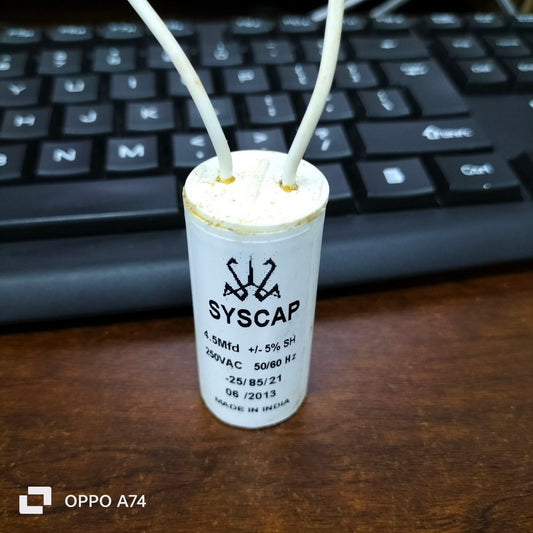 Syscap Motor Running Capacitor 4.5MFD cylindrical white capacitor with two wires on wooden surface