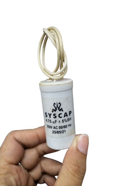 Syscap motor running capacitor 4.75MFD 250V held in hand with white wires attached