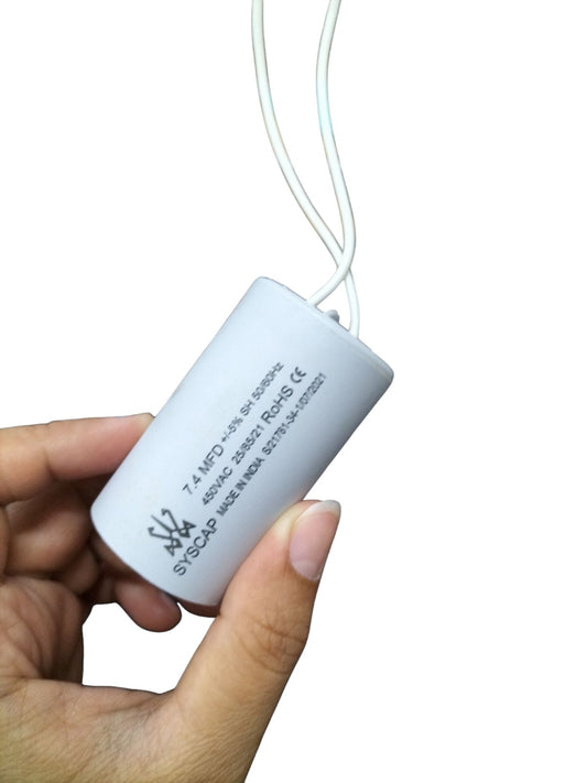 Syscap Running Capacitor 7.4MFD 450 VAC held in hand with white cylindrical body and wires