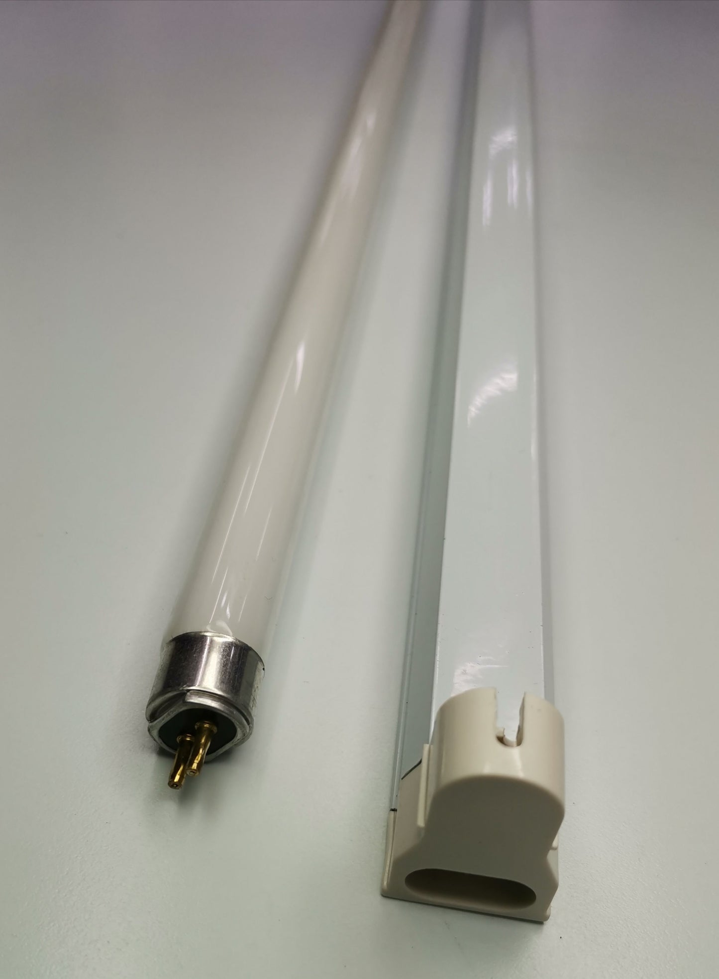 T5 colored fluorescent lamp 220V tube with metal pins and plastic socket connector on white background
