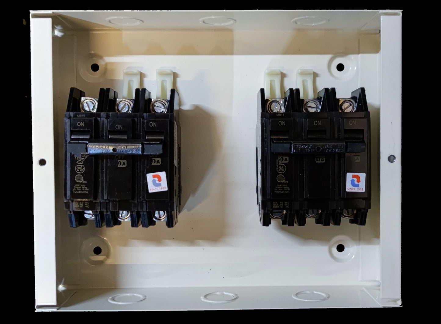 Three Pole Double Throw GE Breaker mounted inside a white electrical panel box from Koten and GE