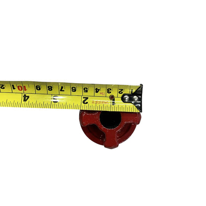 Red threading die head from ratchet pipe threader set with tape measure showing 2 inch diameter on white background