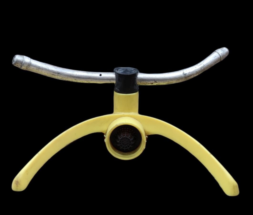 Yellow and silver garden hose sprinkler with curved legs and central nozzle for lawn watering